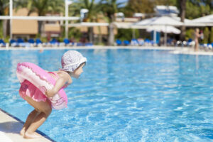 Little girl jumping into a swimming pool