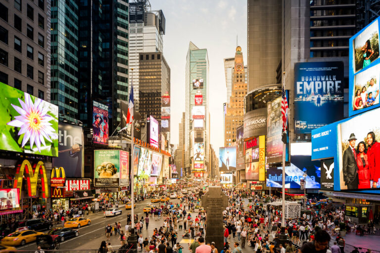 Sunset at a heavily crowded Times Square in New York City, USA. A lot of tourists enjoying the late hours to sit down and watching life here.